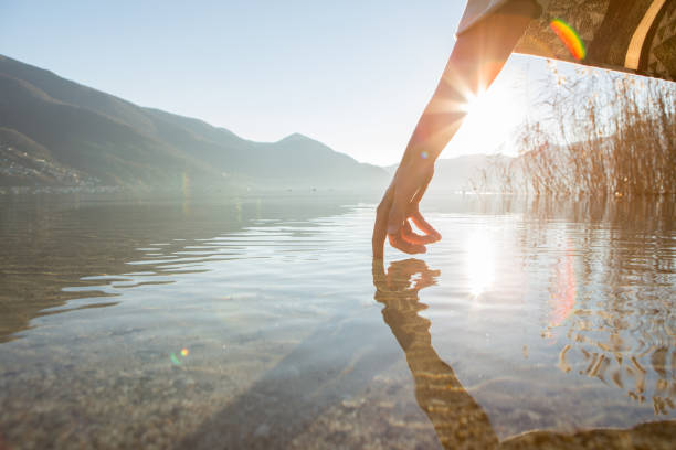 istock Finger touches surface of mountain lake 640242602