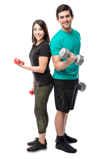 heureux couple soulevant des poids dans un studio - gym muscular build weights two people photos et images de collection