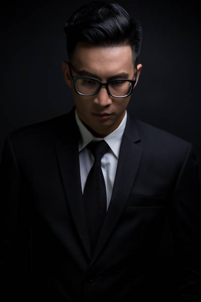 istock Businessman in black suit on isolated black background 640243170