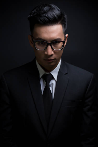 istock Businessman in black suit on isolated black background 640244008