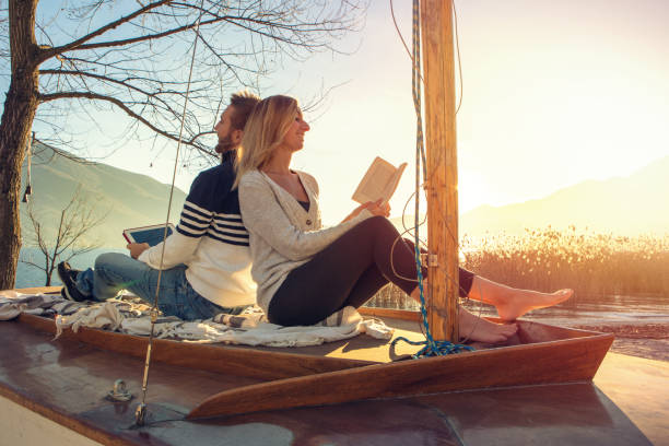 istock Young couple relaxing in nature, reading book and digital tablet 640244018