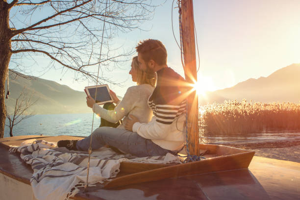 istock Young couple relaxing by the lake using digital tablet 640244210