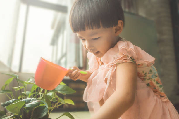 istock asian girl watering plants 640245834