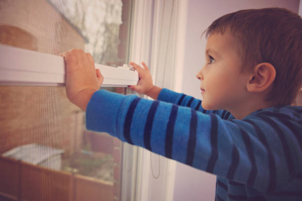 istock Little boy looking outside the window 640248632