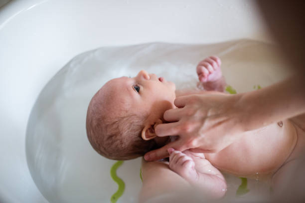 istock Unrecognizable mother bathing her son in white small plastic bat 640249186