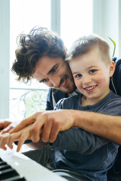 istock Father And Son Playing Piano Together At Home 640249332