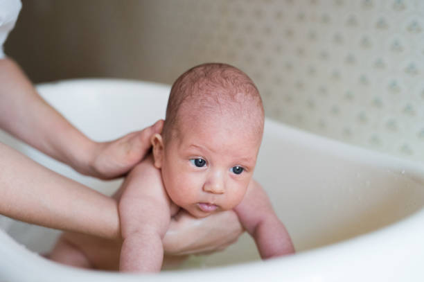 istock Unrecognizable mother bathing her son in white small plastic bat 640249444