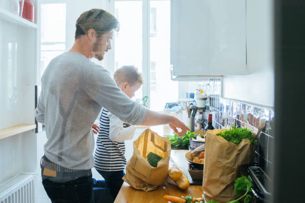 istock Father And Son Organizing Groceries In The Kitchen 640252702