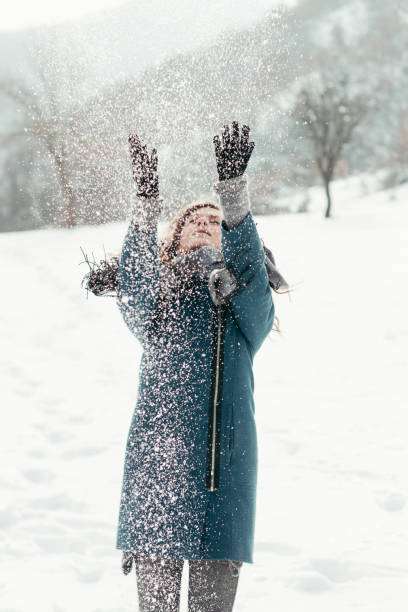 istock Cute young woman playing with snow 640253084