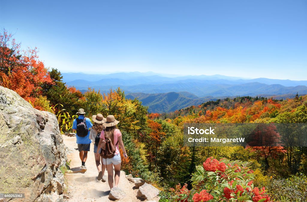 Family hiking on vacation in autumn mountains. People with backpacks hiking on fall trip in mountains. Father with his family enjoying time on a trip. Close to Asheville, Blue Ridge Mountains, North Carolina, USA. Hiking Stock Photo