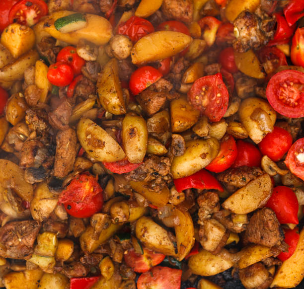 istock Roasted potatoes with meat and tomatoes closeup background 640253164