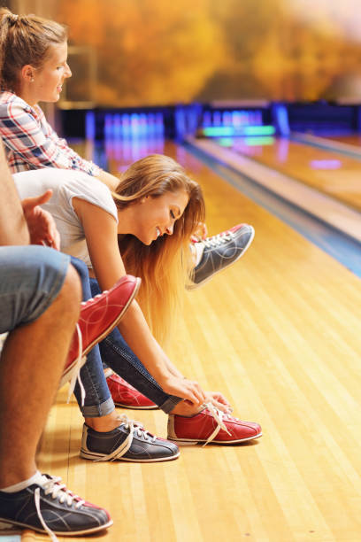 istock Friends putting on bowling shoes 640253236