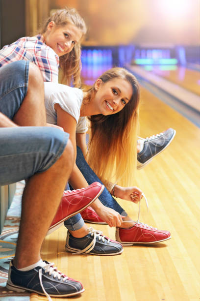 istock Friends putting on bowling shoes 640254454