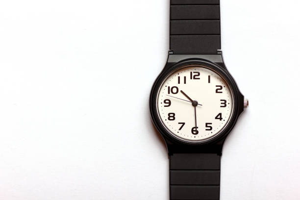 Classic uni-sexual black and white wrist watch on the white background, close up.