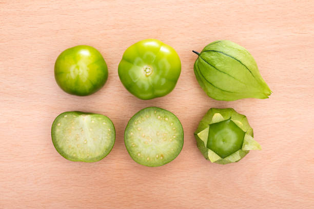 Mexican tomatillos or green tomatoes, called tomates in Mexico on a wooden table.