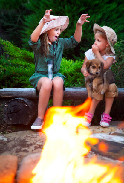 Two sisters talking stories by the campfire in the evening