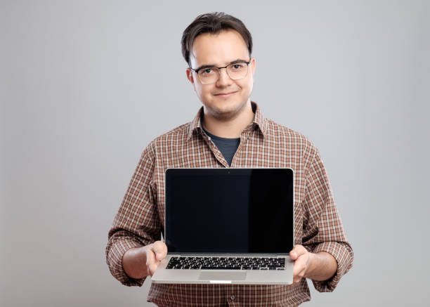 istock Man holding and showing laptop computer 640262622