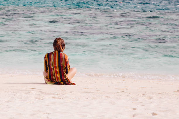 istock Woman is sitting on the tropical sand beach 640263126
