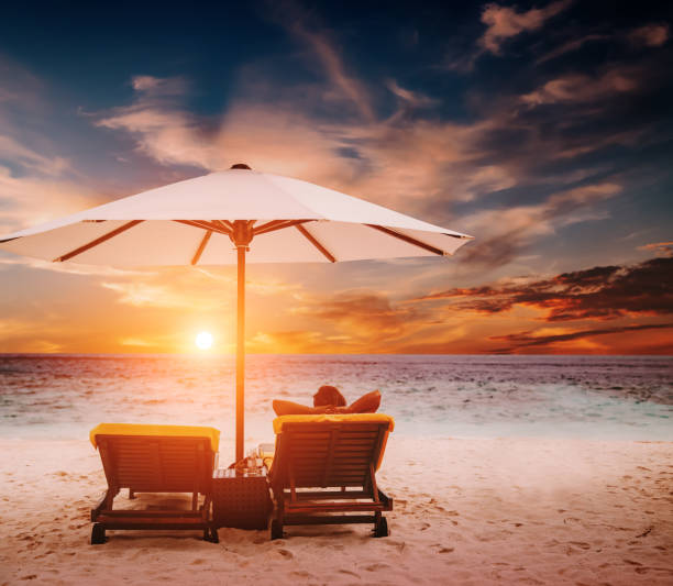 istock Woman on sunbed under umbrella at sunset 640263192