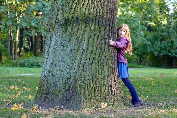istock Girl is hugging a big tree in autumn park. 640264532