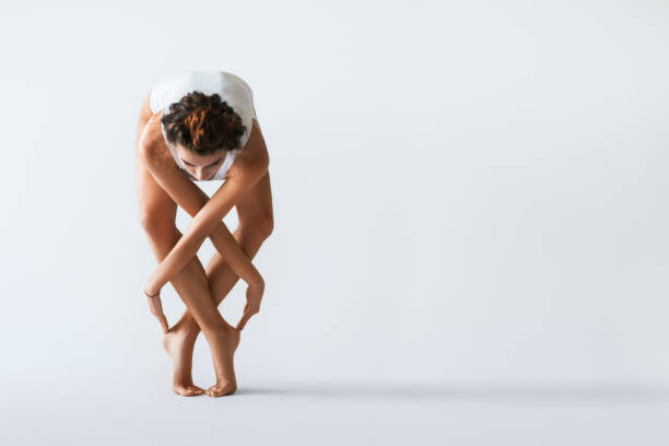 dançarina jovem bonita posando em um fundo do estúdio - yoga posture women flexibility - fotografias e filmes do acervo