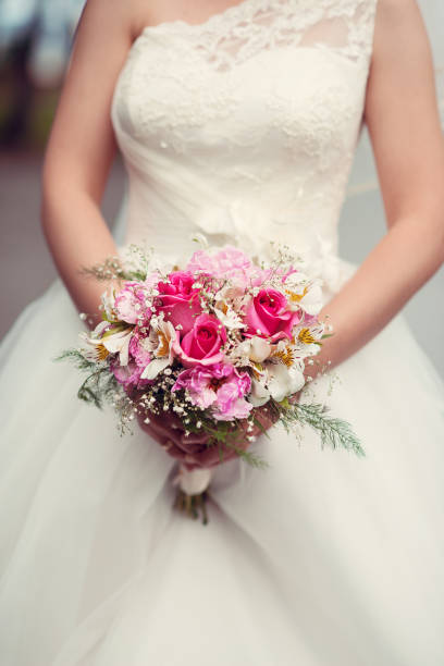 istock Bride holding wedding bouquet of roses. 640267126