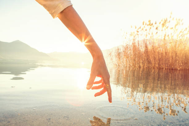 istock Finger touches surface of mountain lake 640271978