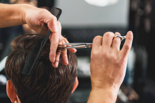 istock Skillful male barber doing haircut 640273790