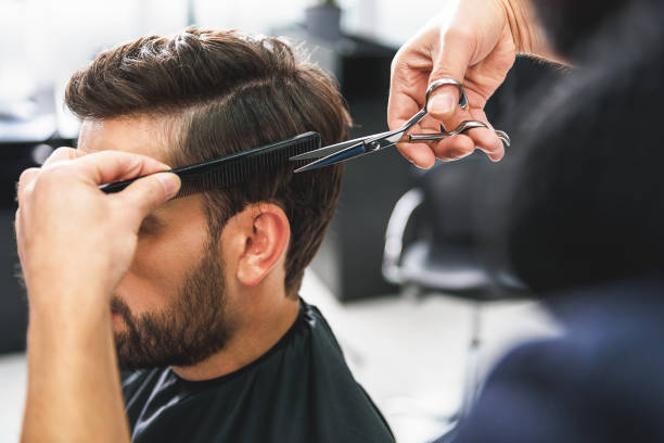 Barber using scissors and comb Close up of hairdresser arms cutting and combing male hair barber shop stock pictures, royalty-free photos & images