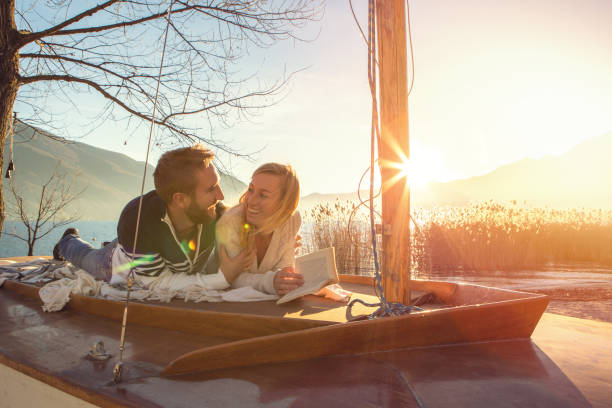 istock Young couple relaxing by the lake reading book 640274978