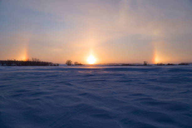 Minnesota Sundogs at Sunset Snowy rural Minnesota landscape with sundogs at sunset. sundog stock pictures, royalty-free photos & images