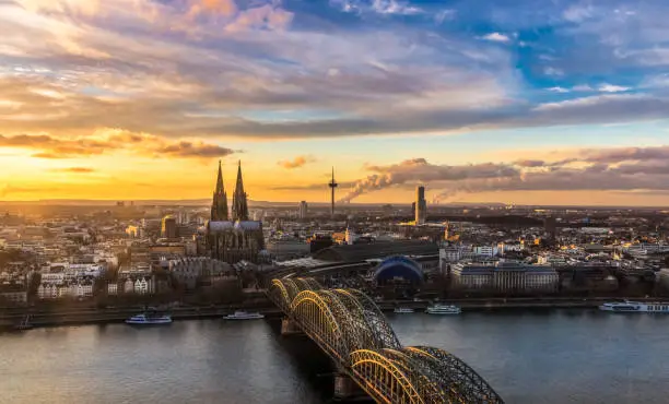 Aerail view through the Dom in Cologne - Hohenzollern bridge above the river rhine in the foreground. Wonderful romantic sunset above the city