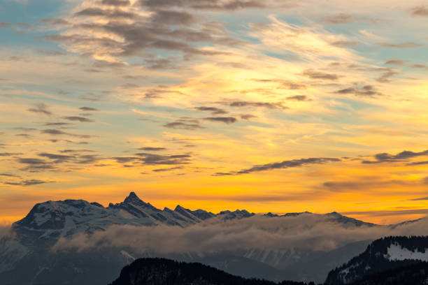 istock Vibrant orange sunset over snowy mountains 640277386