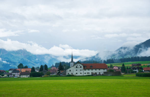 église de charmey village sur les préalpes à gruyère fribourg suisse - swiss cheese chalet town dairy product photos et images de collection