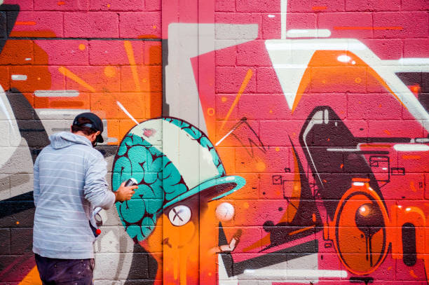 壁に落書きを描く創造的なアーティスト - spray paint spray paint graffiti ストックフォトと画像