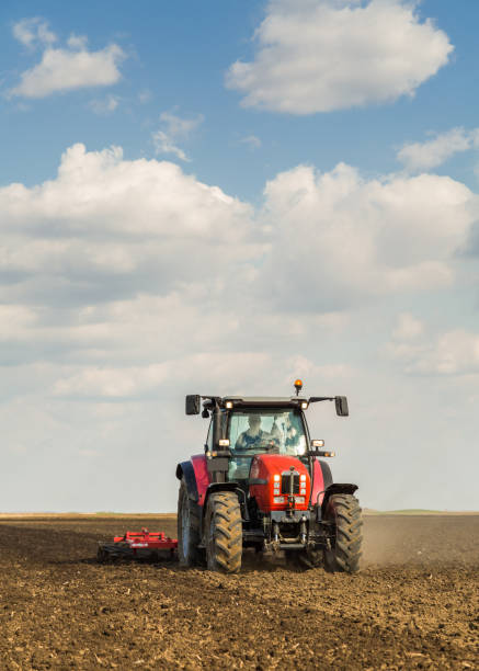 Farmer in tractor preparing land with seedbed cultivator