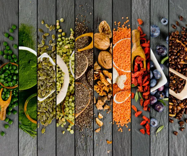 Top view of mixed colorful superfoods scattered on gray slate tile surface