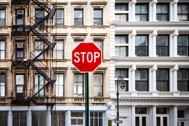 sinal de pare perto de prédios antigos em nova york - one way stop stop sign street - fotografias e filmes do acervo