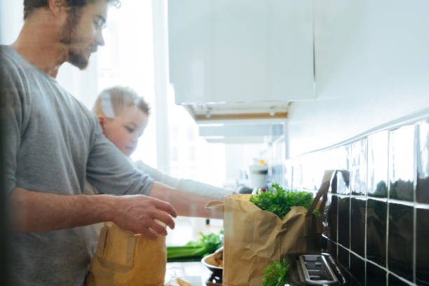 istock Father And Son Organizing Groceries In The Kitchen 640287614