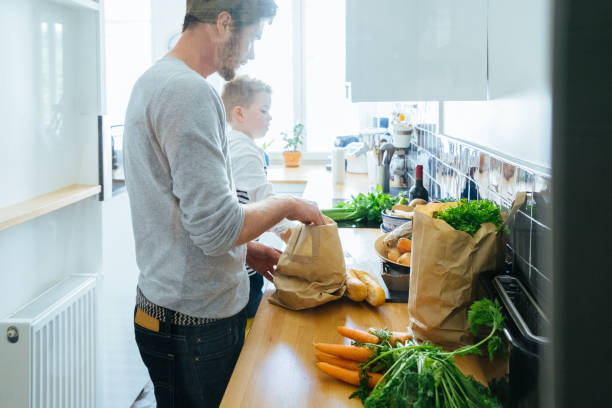 istock Father And Son Organizing Groceries In The Kitchen 640287752