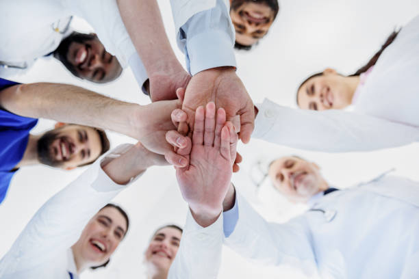 istock Happy general practitioners putting arms together 640287810