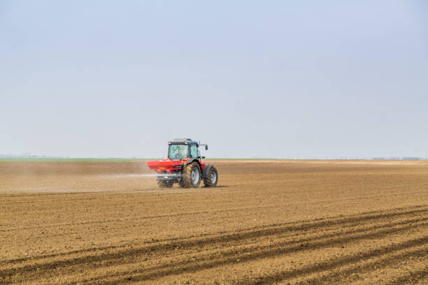 istock Farmer fertilizing arable land with nitrogen, phosphorus, potassium fertilizer. 640289426