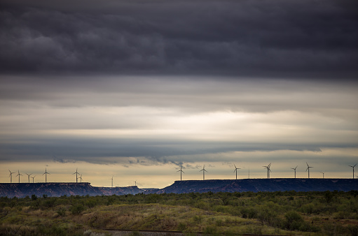 Beams of sunlight shine down through the storm clouds passing over the West Texas plain.