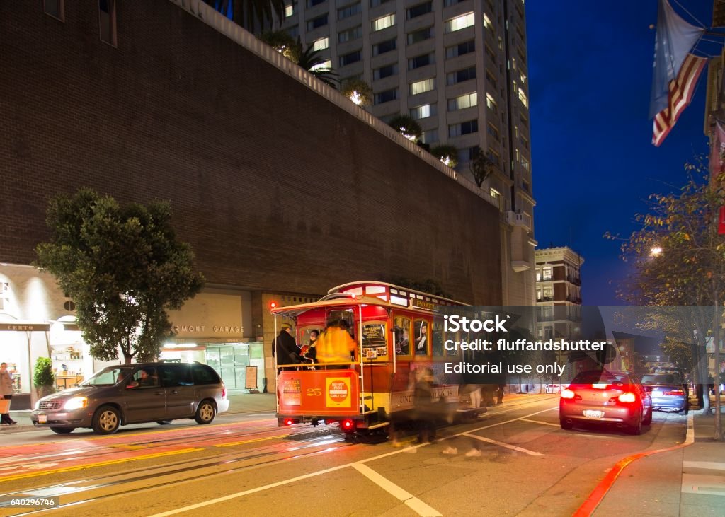 Road with tramway in san francisco at night San Francisco, United States - January 31, 2017: Tourists, Commuters, and cable car operator travelling on the Powell & Hyde Street Cable Car in downtown San Francisco Cable Car Stock Photo