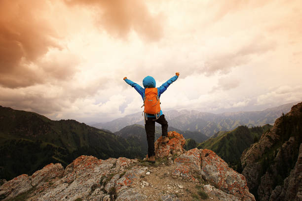 istock cheering successful woman backpacker open arms on mountain peak 640297240