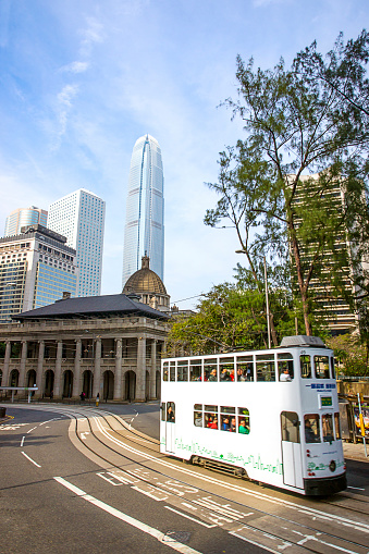 Hong Kong, Hong Kong - January 9, 2012: Road traffic, double tram and Skyscrapers on Hong Kong Island. People in the tram