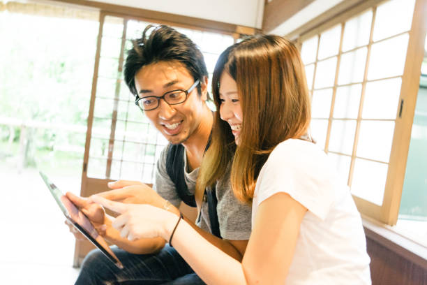 istock Cheerful Japanese friends using tablet indoors 640301318
