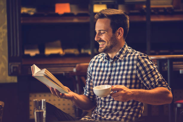 istock Happy man enjoying in a cafe while reading a book. 640302874