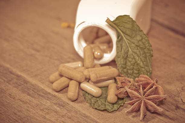 istock Mint leaf and Herb capsule spilling out of a bottle 640306426