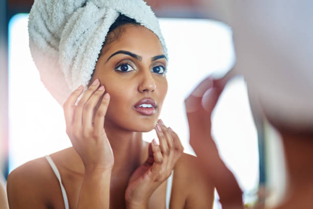 Has my fear of wrinkles finally dawned upon me? Cropped shot of an attractive young woman inspecting her skin in front of the bathroom mirror woman wrapped in bath towel stock pictures, royalty-free photos & images